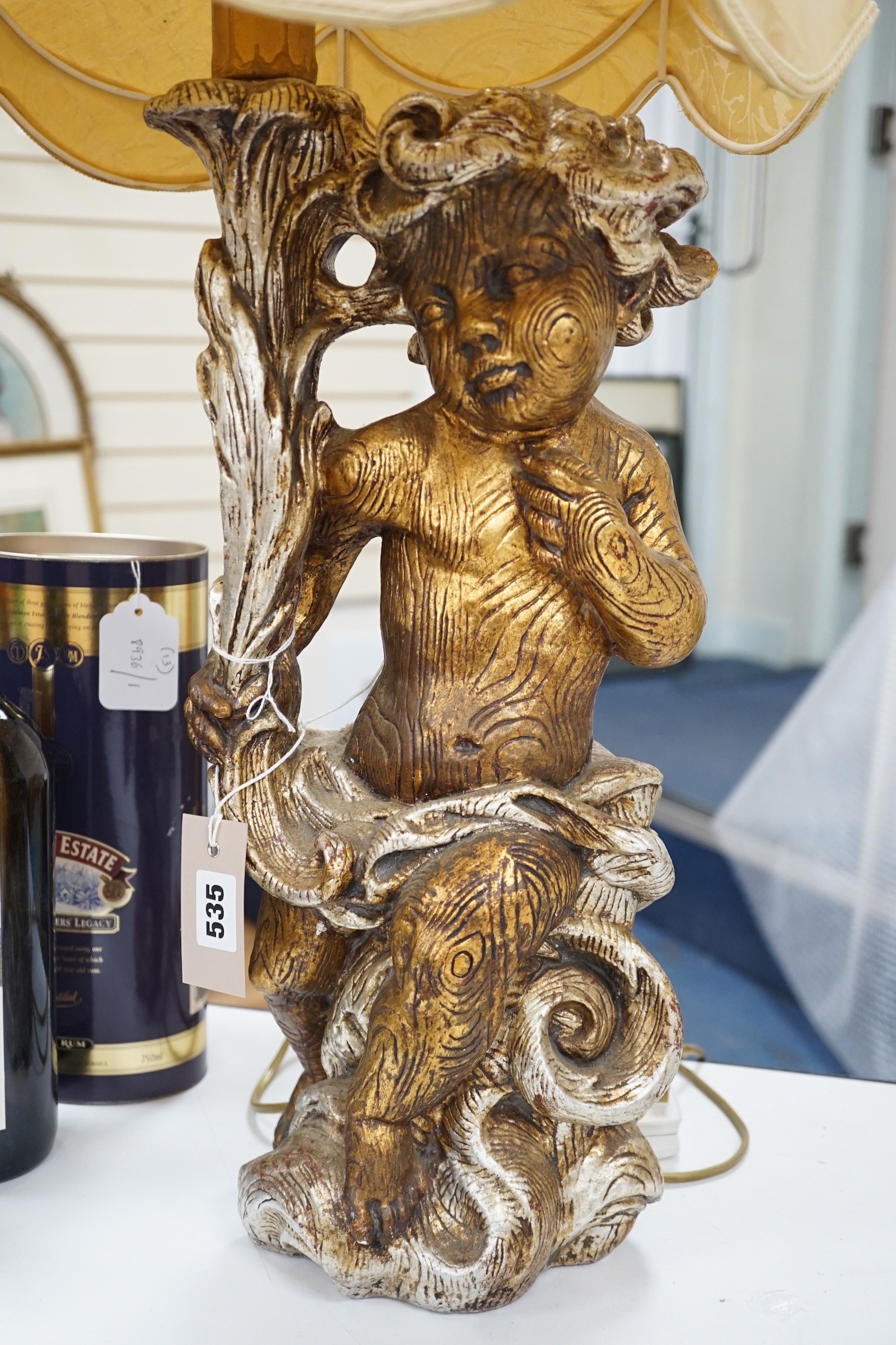 A gilt composition putti table lamp. 86cm tall